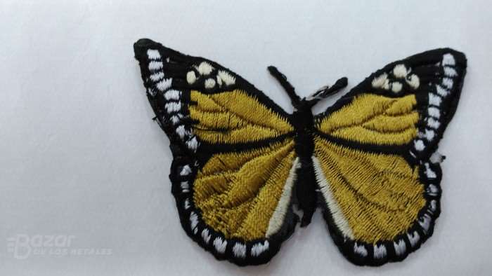 Aplicacion de mariposa en color mostaza de 7 x 5cm.